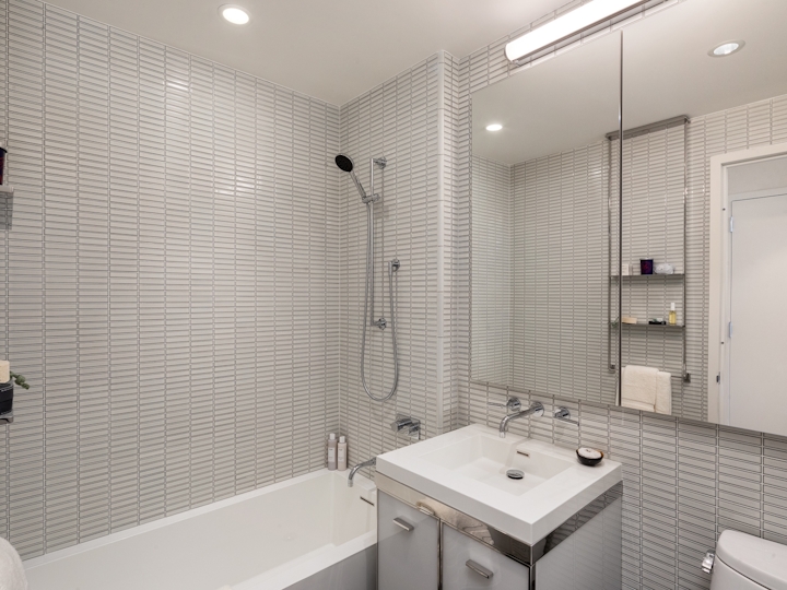 a white sink sitting under a window next to a shower