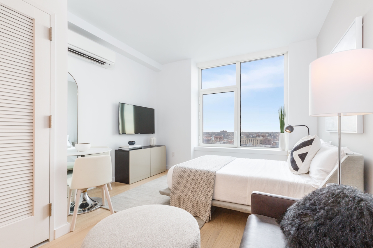 a bedroom with a bed and a chair in a room