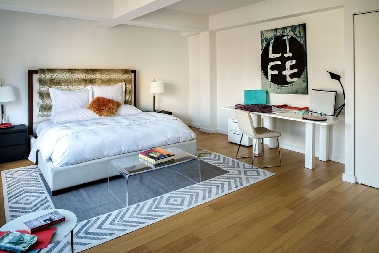 a bedroom with a bed and desk in a room