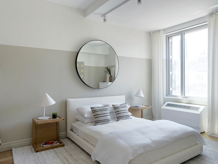 a bedroom with a bed and a mirror