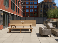 Thumbnail of The Nicole: 11D a bench in front of a brick building