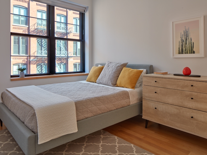 a bedroom with a bed and desk in a room